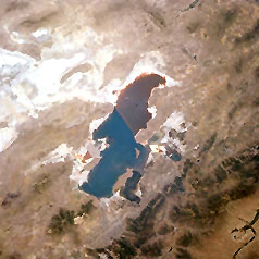 Space Shuttle photo looking northwest and showing the Great Salt Lake, the surrounding deserts and block fault mountains, the Wasatch Range in the foreground; Salt Lake City is not well defined in this image, but when you become more familiar with its location later on this page, come back to pinpoint it.