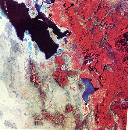 A Landsat-1 (ERTS-1) false color image showing much of north-central Utah, and Great Salt Lake being the dominant feature; Salt Lake City is a bluish area near the center and south-east of the lake; the Wasatch Mountains occupy the eastern third of the image and appear reddish because that is the color 