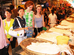 In the market; our students, with Chinese partners, stand bewildered before a huge array of freshly made noodles.