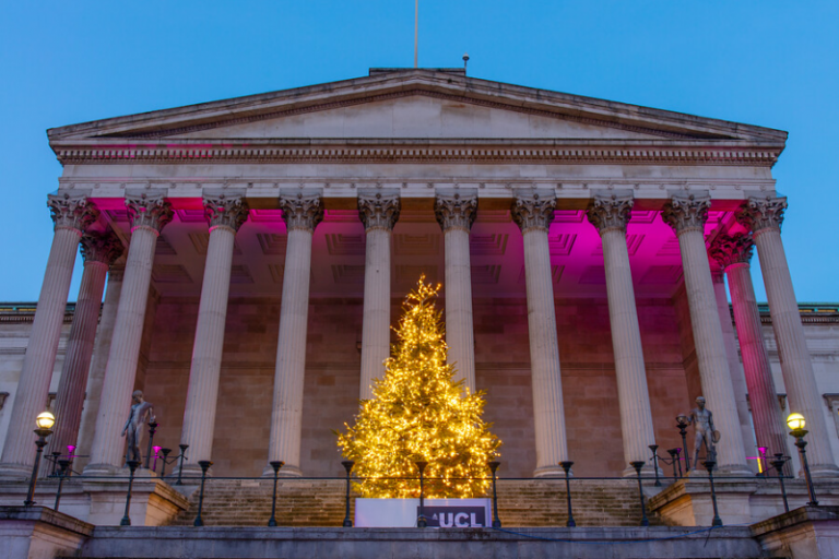 Photo of UCL Portico with pink up-lighting and Christmas tree with white fairy lights