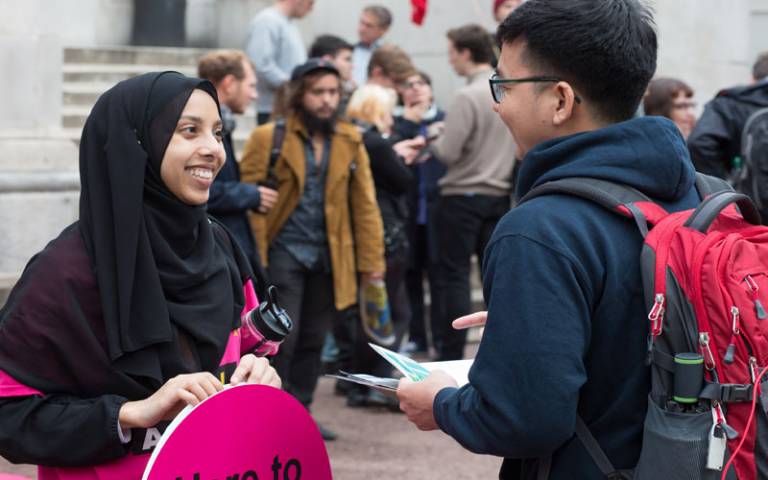 A UCL volunteer chats to a fellow student at an event 