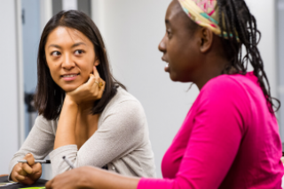 Photograph of UCL Americas Mexican alumna Jessica Harada Fernandez de Lara (l) in conversation with an unidentified black female colleague