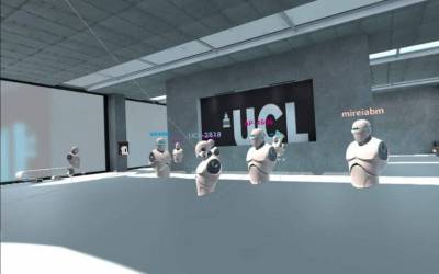 Student avatars interact in a VR room. The robot-like avatars hover in a virtual recreation of a lab with the UCL logo on the wall, each avatar's name is accompanied by the name of the student.