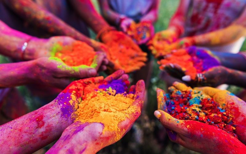 Brightly coloured powder dyes held in hands