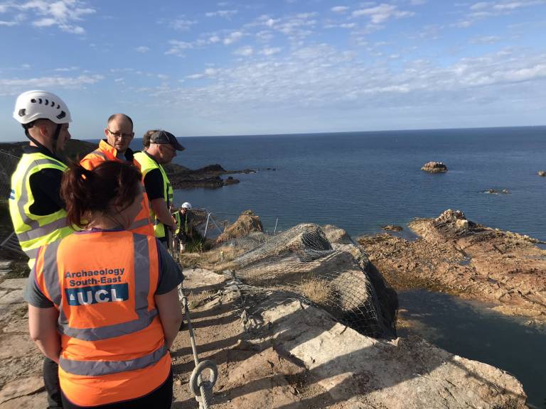 Archaeologists are briefed on their first day on a cliff top