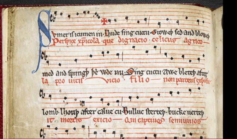 A manuscript written in red and blue-black in showing musical notation. The lyrics are those of Sumor is icumen in.