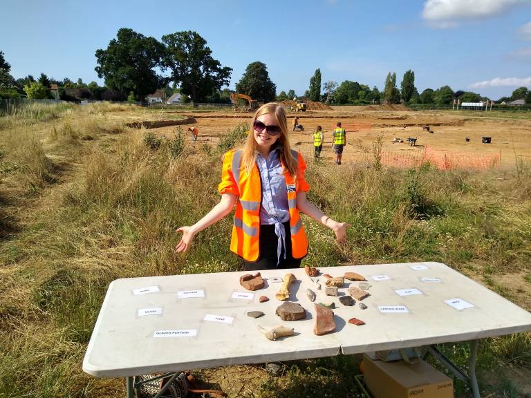 Becca standing with a table of finds