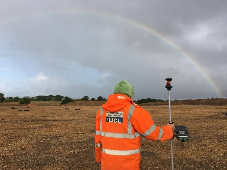 Tom surveying out on site, looking at a rainbow