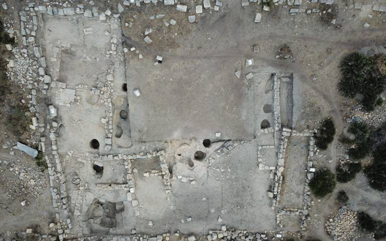 Overhead (drone) image of stone remains of a structure in a sandy desert/scrub landscape