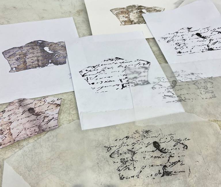 Copies of textile and paper fragments laid out on a table