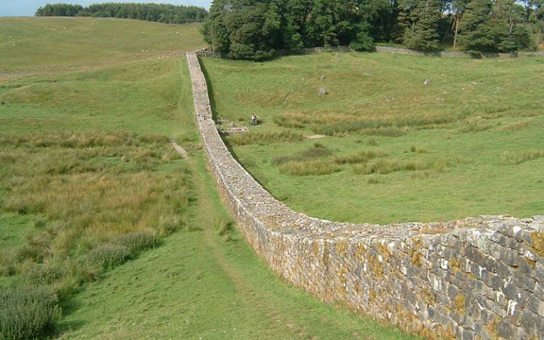 Picture of a wall (Hadrian's wall) running through the landscape (green fields)