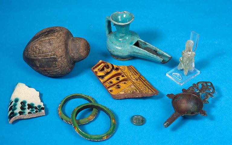 A collection of eight historic objects (Islamic period, pottery, glass, metal) on a blue background