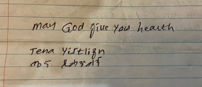 Words 'May God give you health' written on lined paper