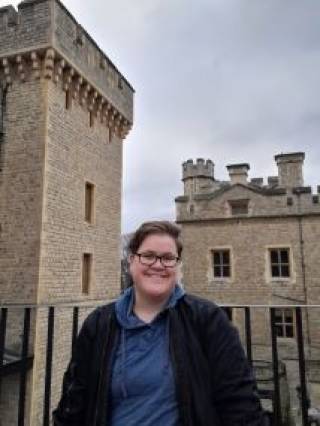 Photo of Tamara Moore smiling at the camera with a castle in the background