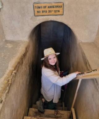 Picture of Paulina Wandowicz wearing a hat and is looking back at the camera as she walks down stairs to a burial chamber 