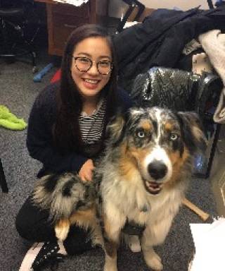 Portrait of Shanna Kang with a dog looking at the camera 