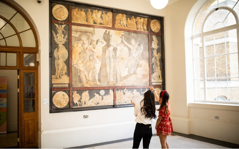 2 art history students looking at a piece of art in The Cloisters UCL