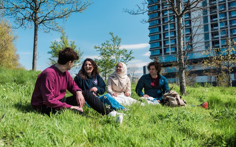 Students sit on the grass at UCL East Marshgate