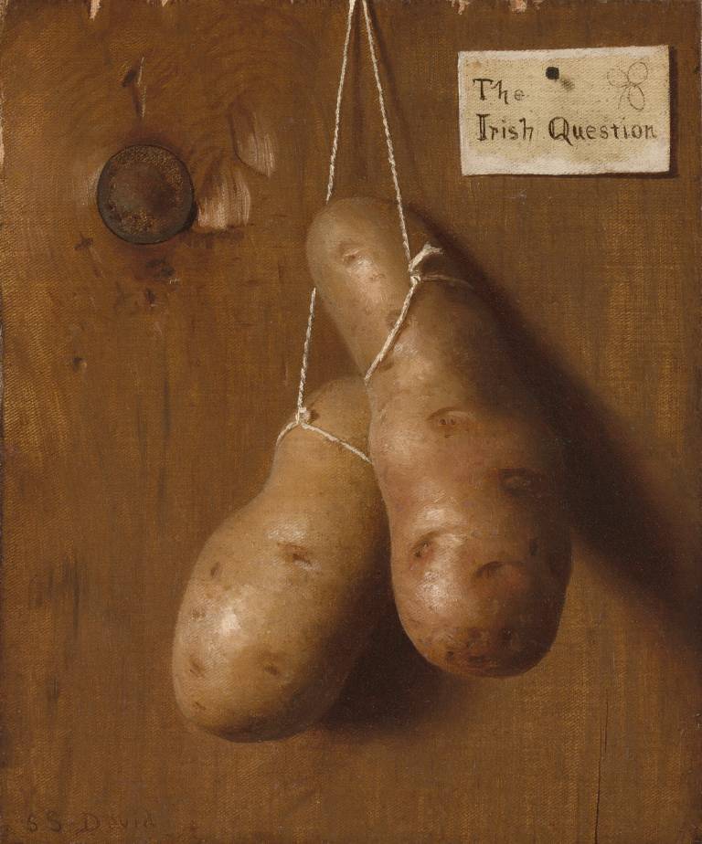 two potatoes tied together against a brown wall