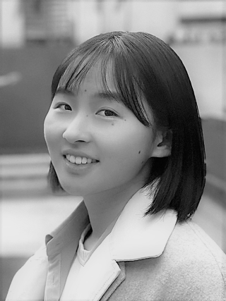 a black and white image of an asian woman smiling at the camera