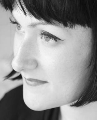 a black and white side profile of a woman with short dark hair and a fringe