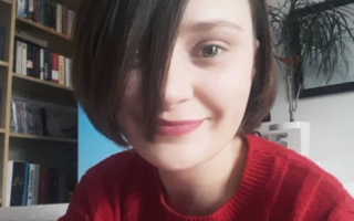 a young woman with short hair smiles at the camera