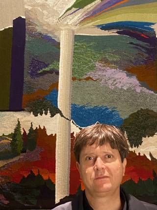A man with dark hair is at the bottom right of the images with a colourful painting behind him