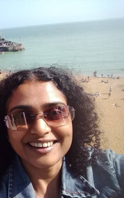 Selfie of Aparna with the sea in the background.