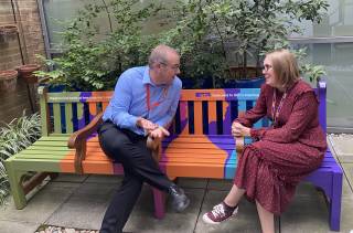 Colleagues chatting at the Happy to Chat bench at Bidborough House