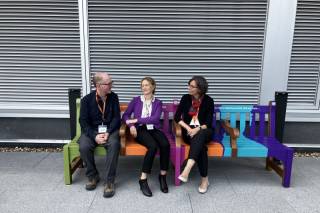 Colleagues chatting at the Happy to Chat bench at UCL East