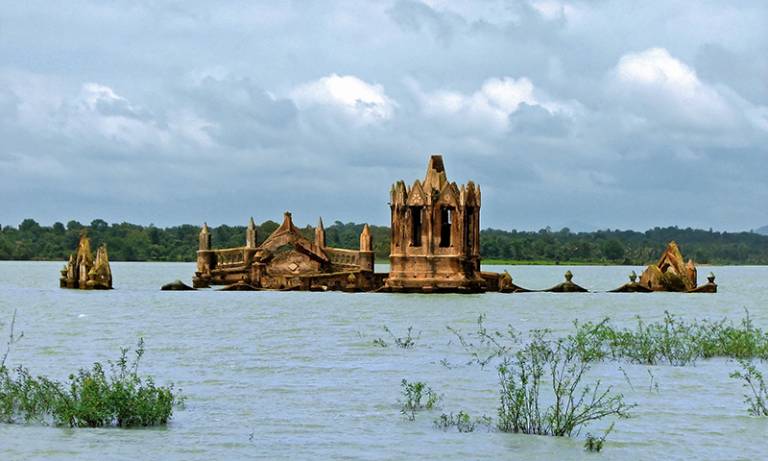 Old ruins emerge from the surface of a lake