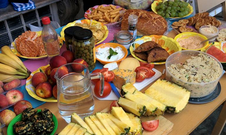 A table of snack food, fruits and vegetables.