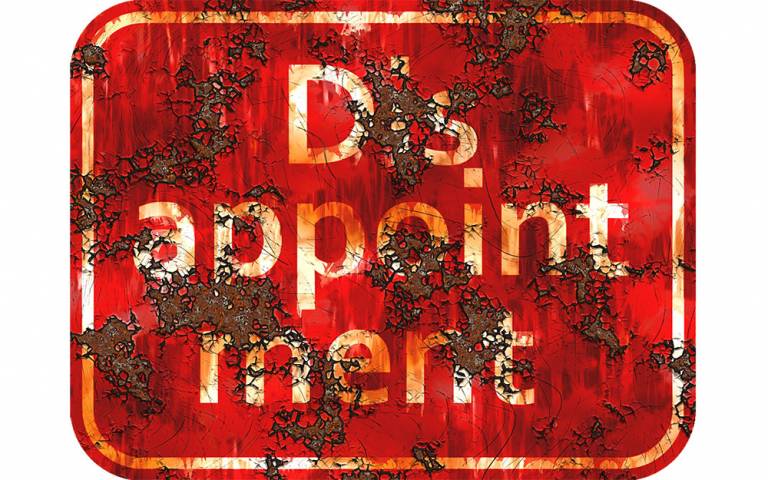 Rusty red sign with white text reading 'disappointment'