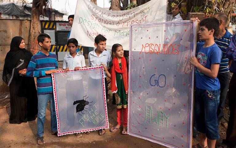 Mumbai students stand outside with their anti-mosquito banners