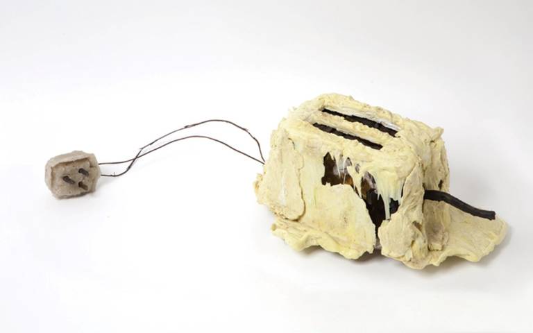An image of a melted toaster - depicting a series of experiments trying to repair, reconfigure and remake the toaster.
