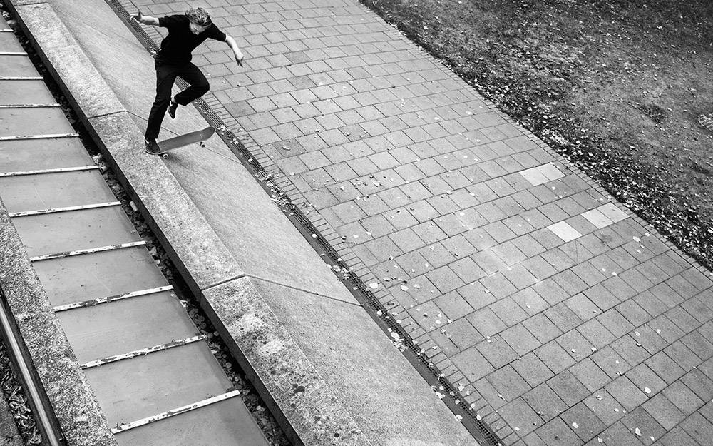 black and white photo of man skateboarding