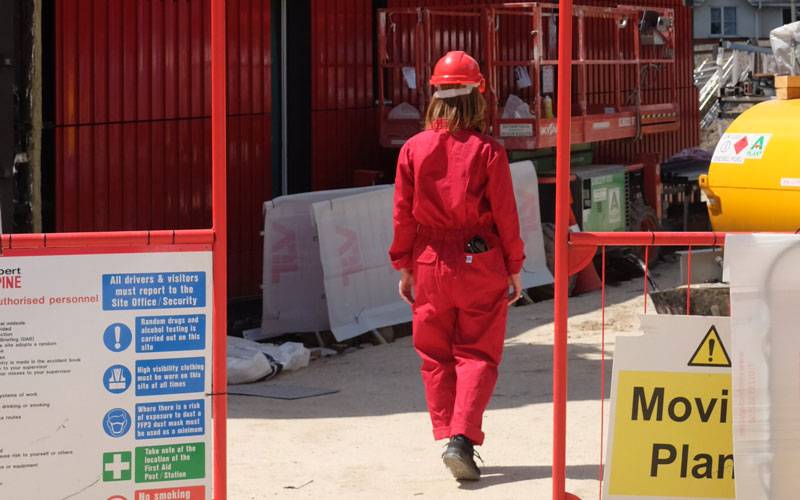 Attending Spaces, by Elin Eyborg Lund. A person in red construction gear, walking away from the camera, through a construction site.