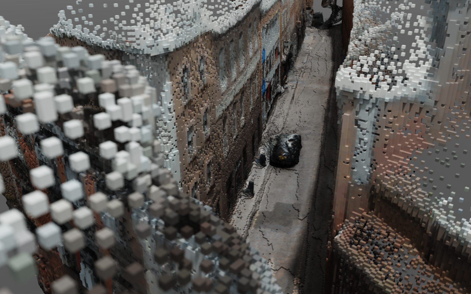 Digital realisation of a city street view looking down from just above the roofs of the surrounding buildings. A single car is visible on the street. The image has been broken down into cubes, like 3-dimensional pixels.