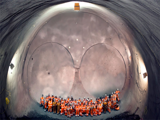 Workmen look on as the tunnel machine, named Elizabeth after the Queen, breaks through into the east end of Crossrail's Liverpool Street station in London.