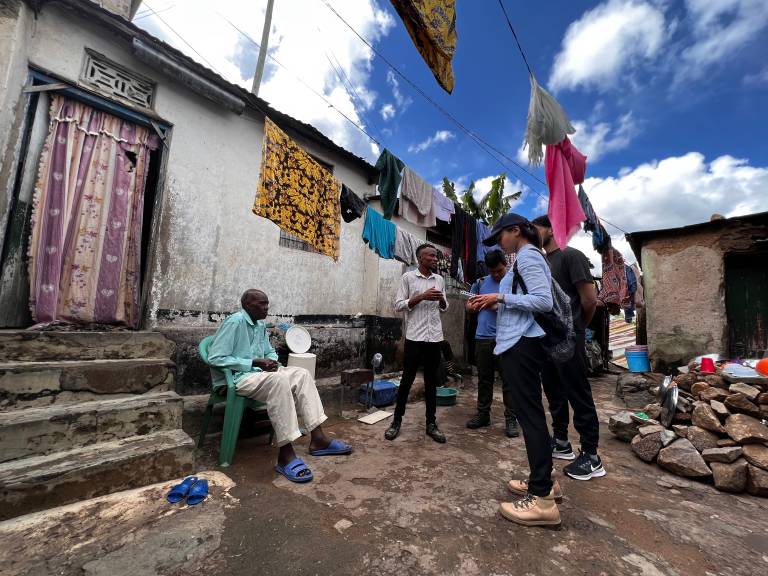 Students and project partners standing outside a settlement in Mwanza, Tanzania
