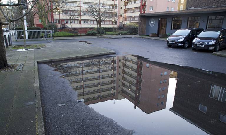 A large pool of water reflecting a building estate