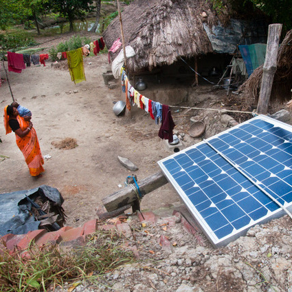 Solar panel and woman in saree in rural Indian village