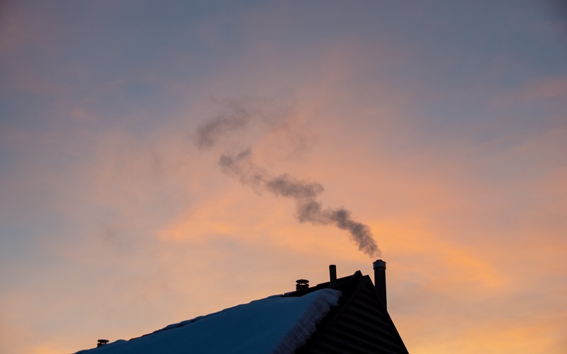 Photo of a house with smoke coming out of the chimney 