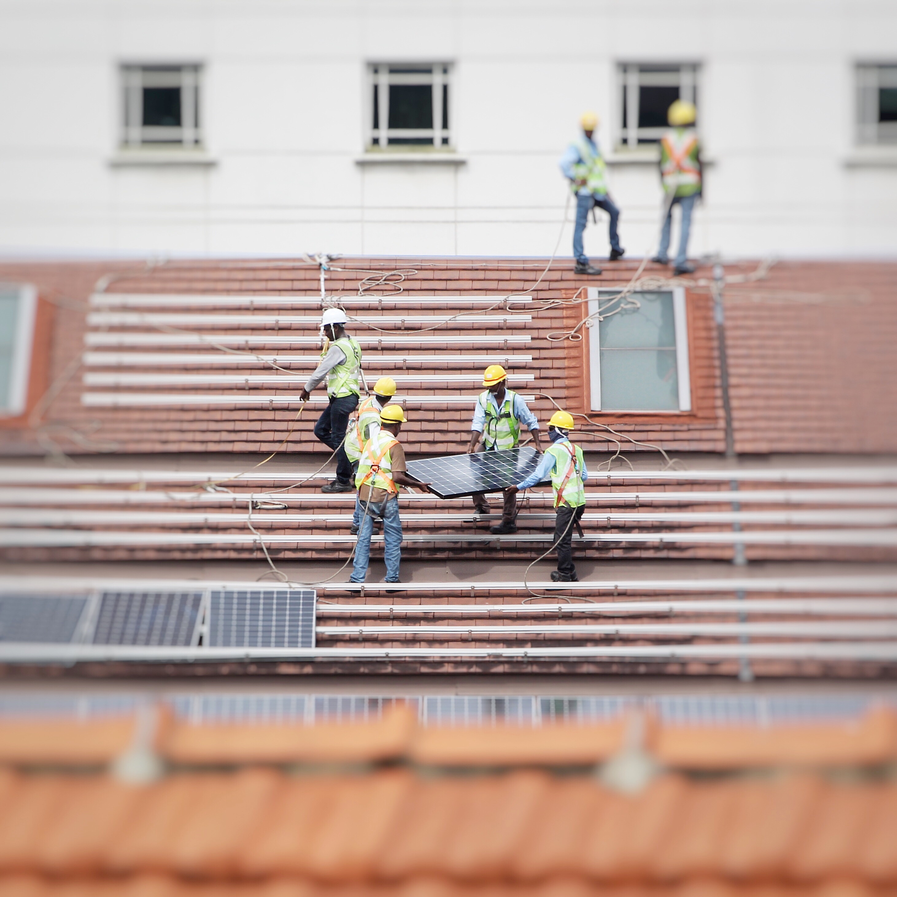 people in high-viz jackets install solar panel