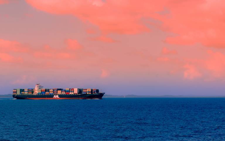 Shipping boat against sunset