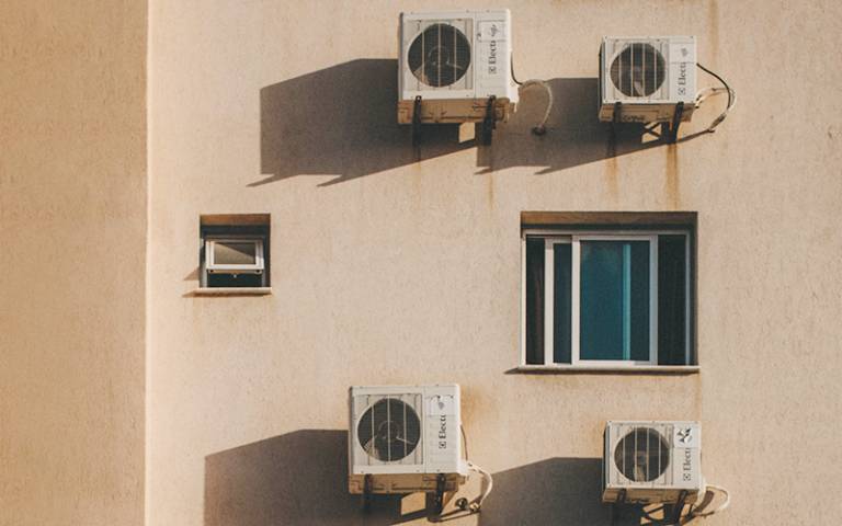 Air conditioning units on the side of an apartment block