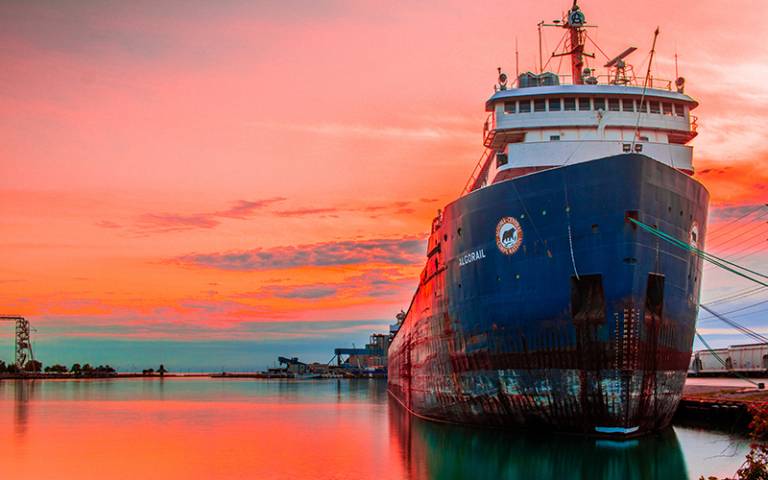 Photo of a cargo ship against a sunset background