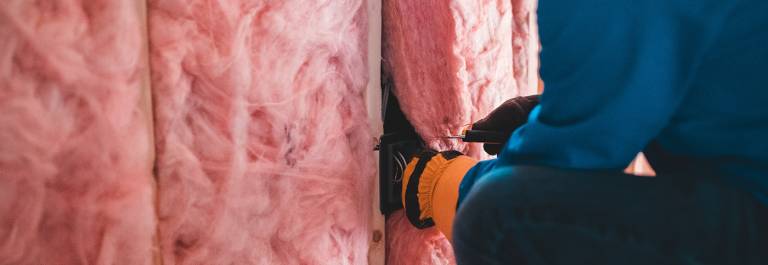 Photo of someone installing loft insulation