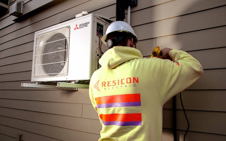 Installation of an air source heat pump on the side of a house