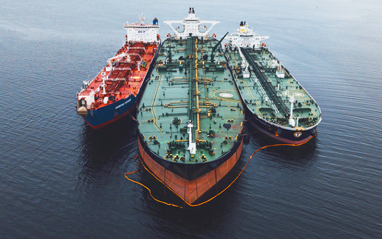 Photo shows three oncoming green and red freight ships.